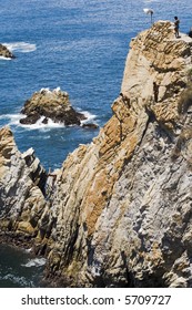 Cliff Diving In Acapulco, Mexico With Diver About To Enter The Water