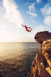 Cliff Jumping Into The Ocean At Sunset, Outdoor Adventure Lifestyle