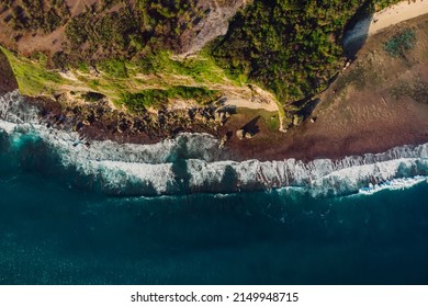 Cliff with rocks and ocean with waves at Bali island. Aerial view in Uluwatu
