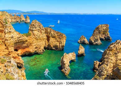 Cliff rocks and tourist boat on sea at Ponta da Piedade, Algarve region, Portugal