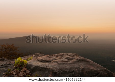 Cliff stone located part of the mountain rock on the top hill with mountain view at sun rise time.
