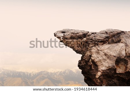 Cliff stone with mountain on clouds sky.