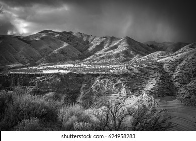 Cliff's Edge with Distant Mountains, Rolling Hills and Stratified Rock.