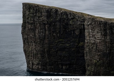 Cliffs of Faroe Islands  Blue ocean below the cliffs  Towering black cliffs on the coast of Faroe Islands