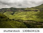 Cliffs and hillsides under a dramatic sky, along the Tugela Gorge hiking route at the base of the Amphitheatre mountain. Drakensberg, South Africa