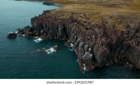 Cliffs and landscape in Iceland, aerial view. Clip. Azure sea and steep stone slope of the shore. - Powered by Shutterstock