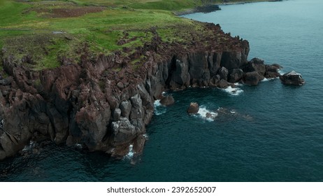 Cliffs and landscape in Iceland, aerial view. Clip. Azure sea and steep stone slope of the shore. - Powered by Shutterstock