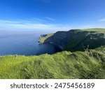 Cliffs of Moher on perfect sunny day with clear blue skies in summer, vibrant greens and blues