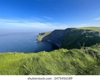 Cliffs of Moher on perfect sunny day with clear blue skies in summer, vibrant greens and blues - Powered by Shutterstock