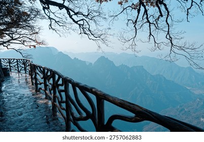 Cliffside railing overlooking blue mountain layers on Tianmen Mountain.