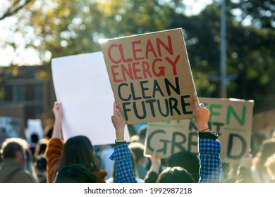 Climate change protest in Melbourne Australia with people holding banners, focus on sign saying clean energy clean future. Global warming and protecting the environment concept.  - Shutterstock ID 1992987218