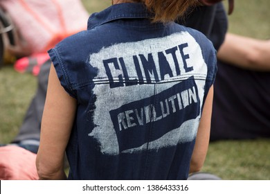 A climate change protestor wearing a top with climate revolution painted on