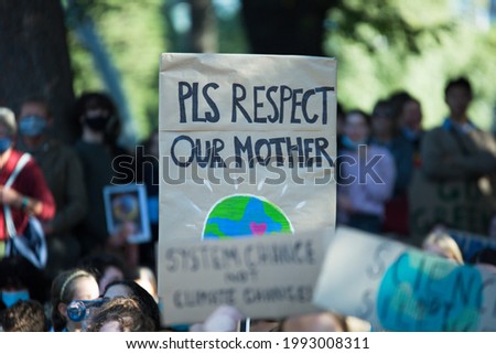 Climate change strike - people holding banners and signs saying please respect our Mother Earth. Protest against global warming. Text and pictures of planet earth. Climate action concept.