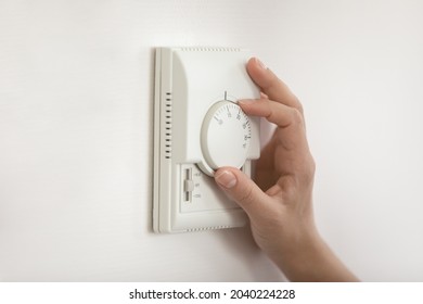 Climate Control. Close Up Of Young Woman Hand Switch On Temperature Regulator On Wall Mounted Panel Turn Controller To Change Thermostat Position. Easy Adjusting Of Modern Heating System At Smart Home