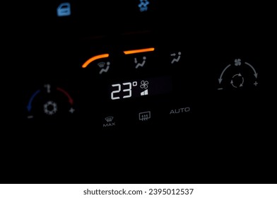 climate control unit in a modern car is highlighted in the dark - Shutterstock ID 2395012537
