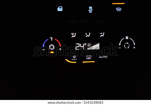 climate control unit in a modern car is highlighted\
in the dark