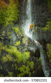 Climber abseiling down a cliff