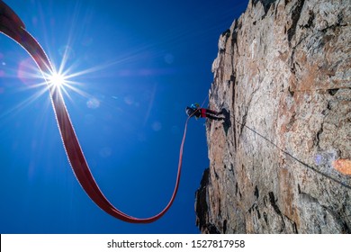 Climber Abseiling The Steep Rocky Ridge