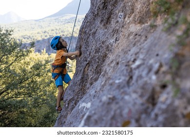 climber boy. the child trains in rock climbing. sports in nature. - Powered by Shutterstock