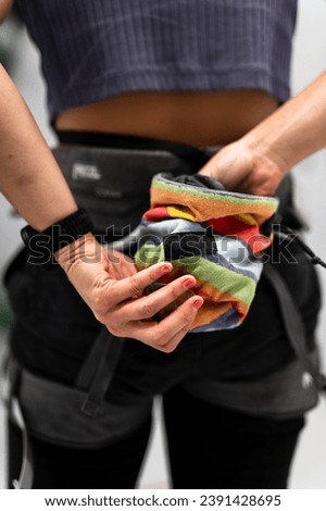 Climber chalking her hands in a chalk bag