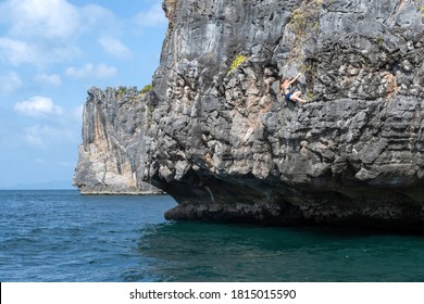  Climber Climbs The Rock Above The Sea. Rock Climbing (deep Water Solo) In Thailand.