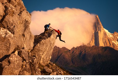 Climber Helping His Partner To Get Over The Cliff Edge 