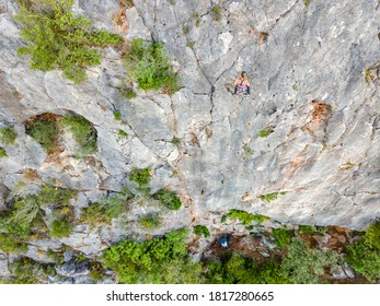 Climber high on the rock while another secures him from the ground level