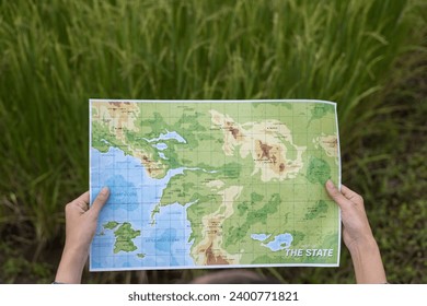 The climber is looking at a map  to study the route of the hike.