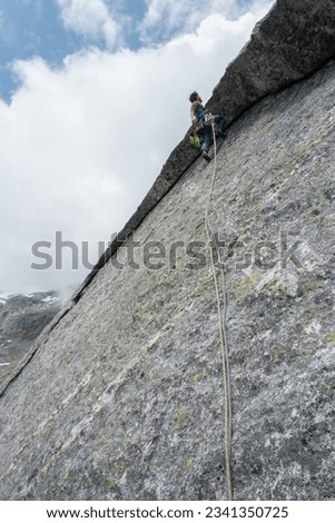 Climber on steep mountain wall in the Alps of Italy