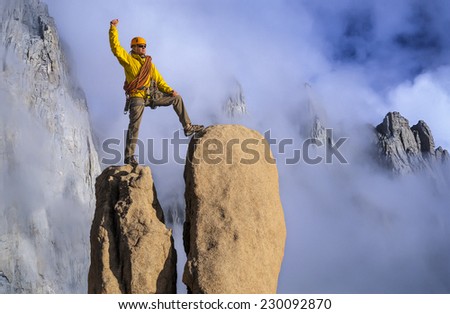 Climber on the summit of a challenging cliff.