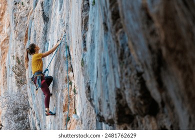 Climber overcomes challenging climbing route. A girl climbs a rock. Woman engaged in extreme sport. Extreme hobby.
 - Powered by Shutterstock