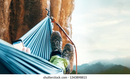 Climber resting in hammock on the vertical cliff wall. - Powered by Shutterstock