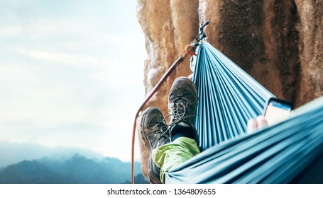 Climber resting in hammock on the vertical cliff wall - Powered by Shutterstock