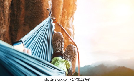 Climber resting in hammock on the vertical cliff wall - Powered by Shutterstock