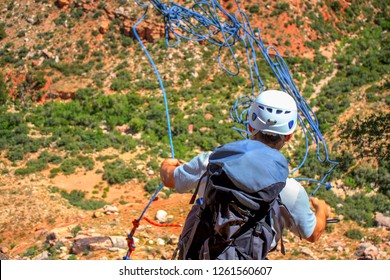 A Climber Throwing A Climbing Rope Down From The Top Of A Climb