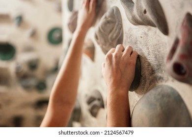 Climber wearing in climbing equipment. Practicing rock-climbing on a rock wall indoors. Xtreme sports and bouldering concept. - Powered by Shutterstock