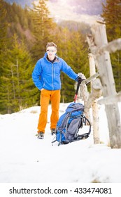 The climber wears a backpack before climbing into the mountains in the snow.
