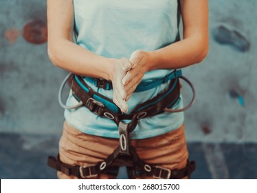 Climber woman coating her hands in powder chalk magnesium and preparing to climb indoor, close-up - Powered by Shutterstock