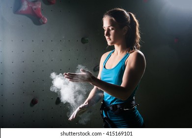 Climber woman coating her hands in powder chalk magnesium - Powered by Shutterstock