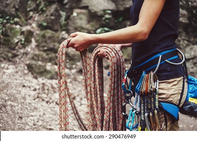 Climber Woman Wearing In Safety Harness With Equipment Holding Rope And Preparing To Climb