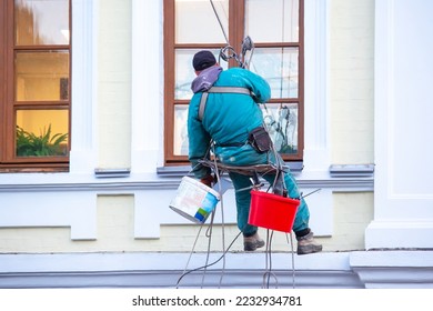 climber worker maintains a window and facade of a residential building in repair. construction business industry - Shutterstock ID 2232934781