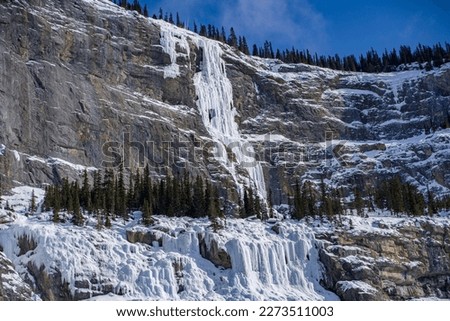 climbers climbing up on frozen waterfall on rock in jasper and naff national park