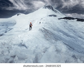 Climbers with trekking poles and crampons walk up icy slope to top of snow capped mountain at sunny day, Caucasus Mountains - Powered by Shutterstock