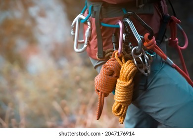 Climbing equipment, ropes, carabiners, harness, belay, close-up of a rock-climber put on by a girl, the traveler leads an active lifestyle and is engaged in mountaineering. - Shutterstock ID 2047176914