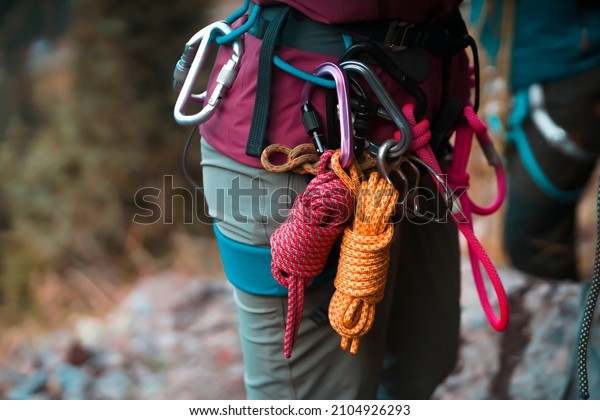 Climbing\
equipment, ropes, carabiners, harness, belay, close-up of a\
rock-climber put on by a girl, the traveler leads an active\
lifestyle and is engaged in\
mountaineering.