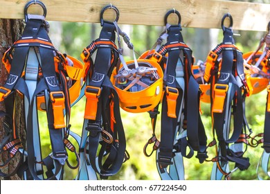 Climbing Gear Equipment - Orange Helmet Harness Zip Line Safety Equipment Hanging On A Board. Tourist Summer Time Adventure Park Family And Company Team Building Concept For Extreme Recreation Sports