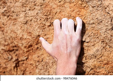 Climbing Hand Closeup Grip During Rock Climbing. Male Hand With Chalk Powder On Rocks.