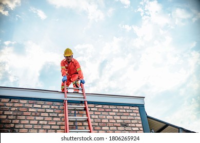 Climbing the risks of a worker by ladder to work on the roof of a house on a beautiful sunny day. - Powered by Shutterstock