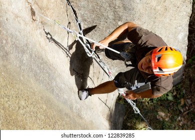 Climbing Rock Safety Harness Outdoor Helmet Adventure Mountain Man Climber Up Face Stone Mountaineer Closeup Shoot From Above Climbing Rock Safety Harness Outdoor Helmet Adventure Mountain Man Climber