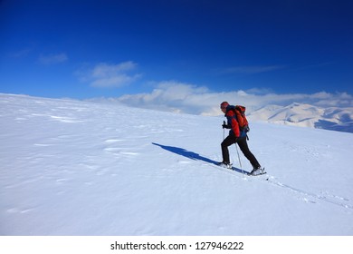 Climbing the snowy mountain on ski during winter